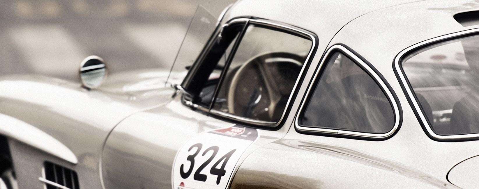 Champagne Mercedes-Benz 300 SL Gullwing with racing number 324, photographed from the side